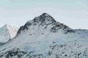 Misty majestic views of snow capped glacier peaks over the volcanic ridges of Mount Stanley during an official rwenzori mountains hiking tour