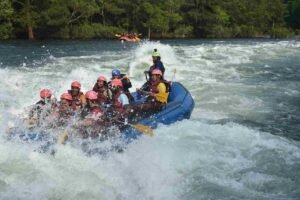 A team of outdoor explorers navigating an explosive grade 5 rapid during an official white water rafting uganda river excursion