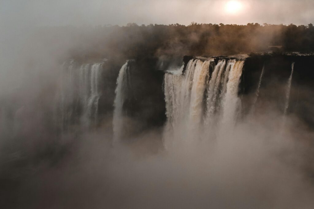 pexels-photo-1637146-1637146 A stunning view of a grand waterfall enveloped by mist, showcasing nature's beauty.